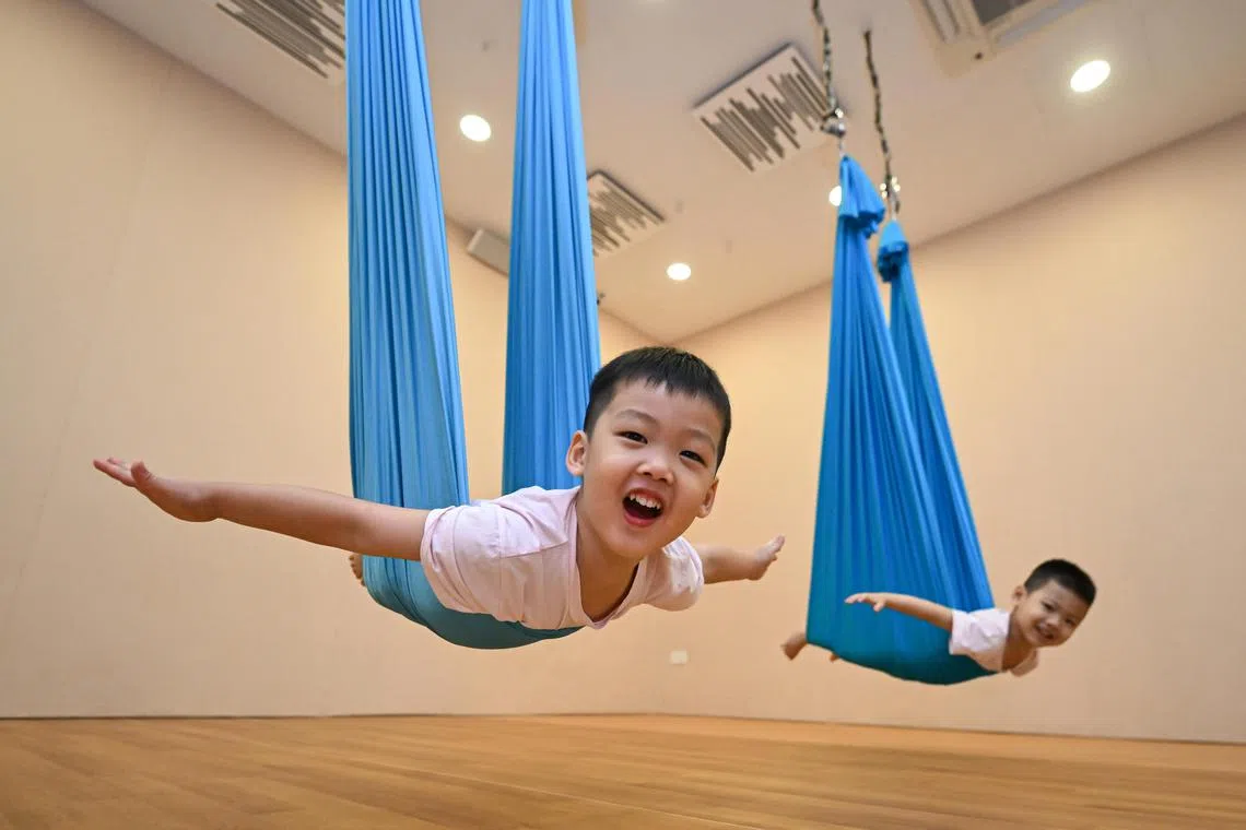 (From left) Twins Axel and Lloyd Tan, both three, during an aerial yoga class at Mindful Space on June 24, 2023.