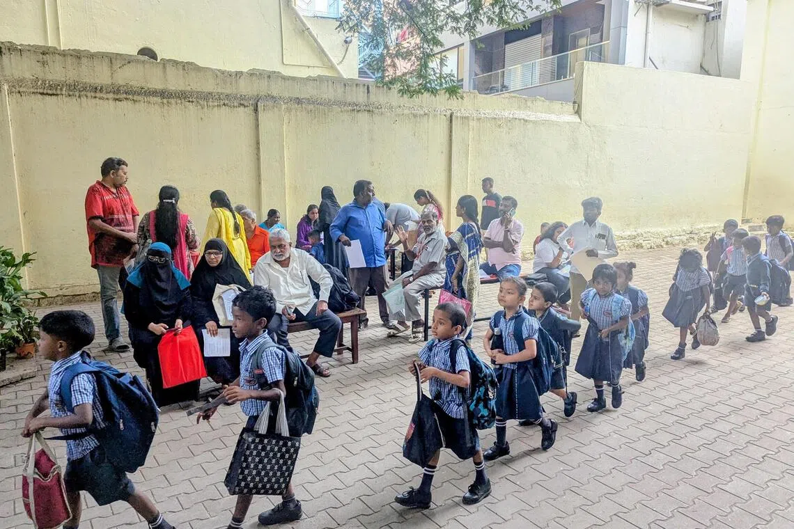 Voters whose names have been flagged for deletion under the Special Intensive Revision in India wait at a Bengaluru school to get their identification documents verified by election officials.