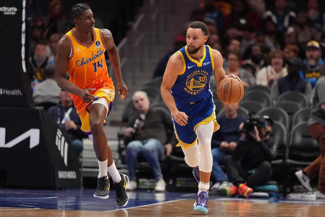 Golden State Warriors guard Stephen Curry brings the ball up court followed by Charlotte Hornets forward Moussa Diabate during the second half at Spectrum Center. 