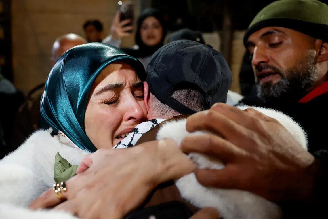 People embrace as Palestinian prisoners arrive on a bus after they were released from an Israeli jail on Feb 27.