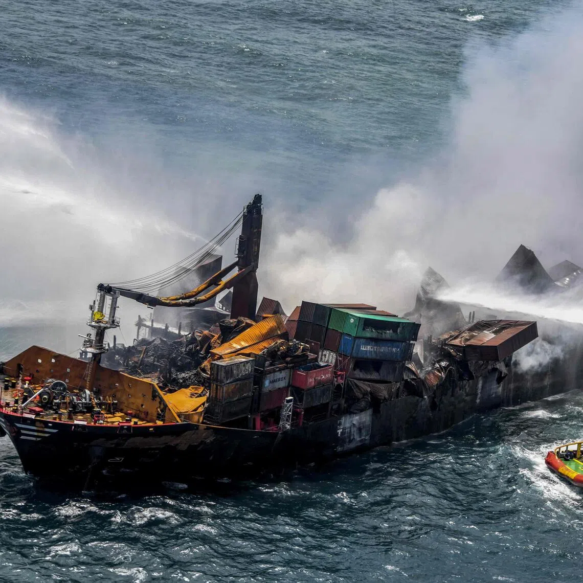 Smoke billowing from the Singapore-registered container ship MV X-Press Pearl as vessels try to douse off the fire, in the sea off Sri Lanka's Colombo Harbour on May 30, 2021.