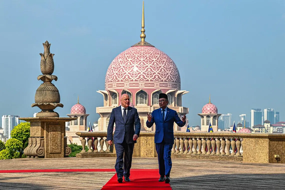 Malaysia's PM Anwar Ibrahim (right) talking with New Zealand's PM Christopher Luxon after a welcoming ceremony in Putrajaya. 