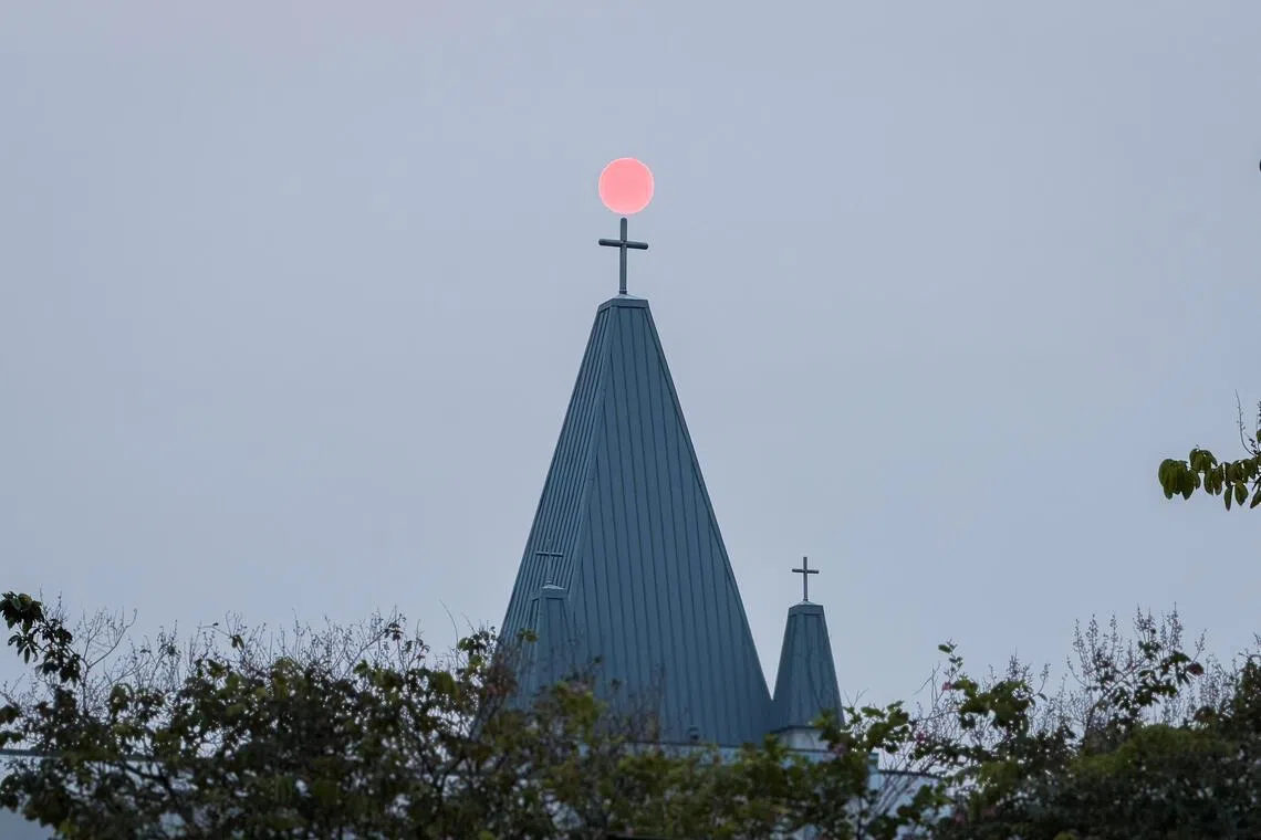A red sun sets behind a cross at CHIJ Secondary (Toa Payoh) on Oct 8, 2026.