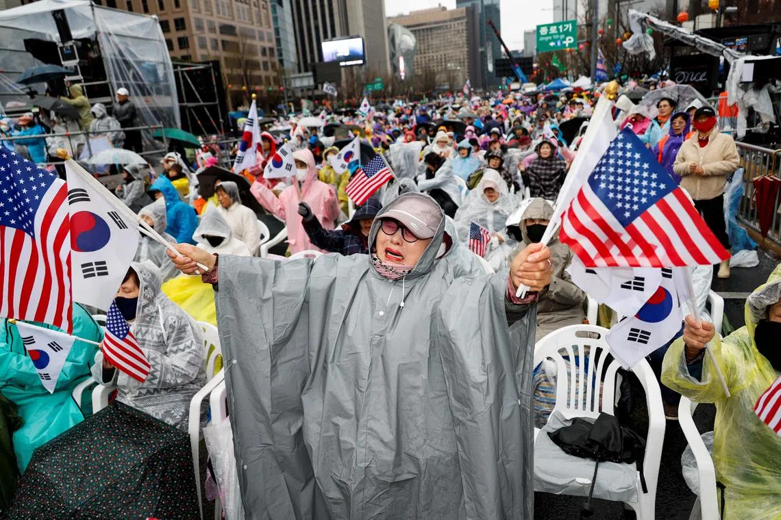A far-right protester holding U.S. and South Korean flags attends a rally to support South Korean ousted President Yoon Suk Yeol in Seoul, South Korea, April 5, 2025. REUTERS/Kim Soo-hyeon