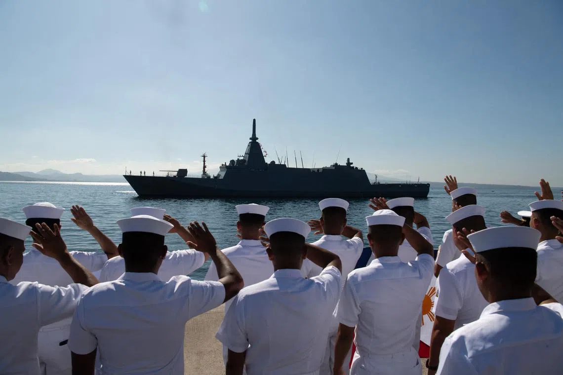 Sailors from the Philippines waving as the Japanese Maritime Self-Defence Force frigate JS Noshiro arrives at their naval operating base in Subic town, in the province of Zambales, on March 26.