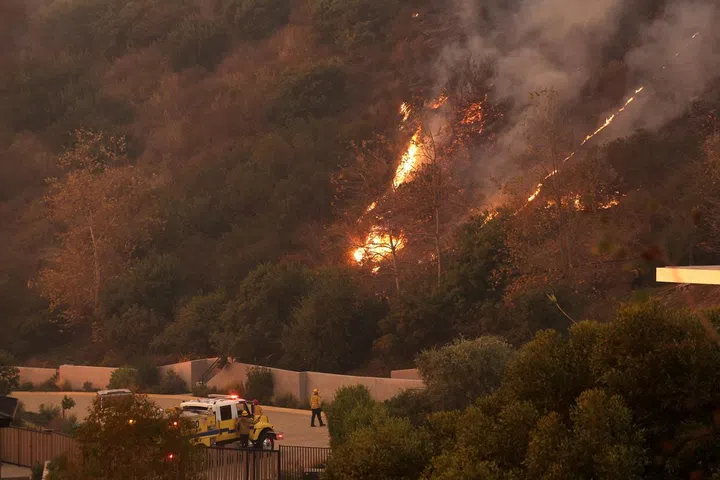 Os bombeiros observam as chamas e a fumaça subindo enquanto o incêndio Franklin queima em Malibu, Califórnia, EUA, 10 de dezembro de 2024. REUTERS/Mario Anzuoni