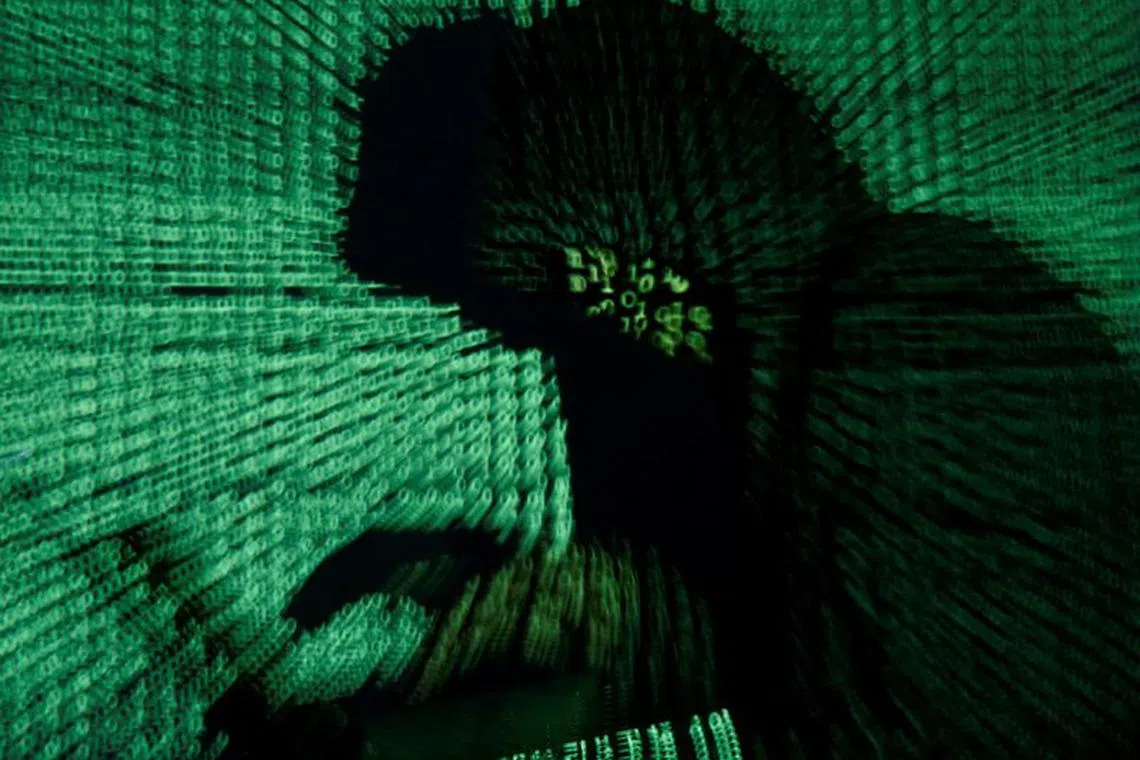 FILE PHOTO: A man holds a laptop computer as cyber code is projected on him in this illustration picture taken on May 13, 2017. REUTERS/Kacper Pempel/Illustration/File Photo