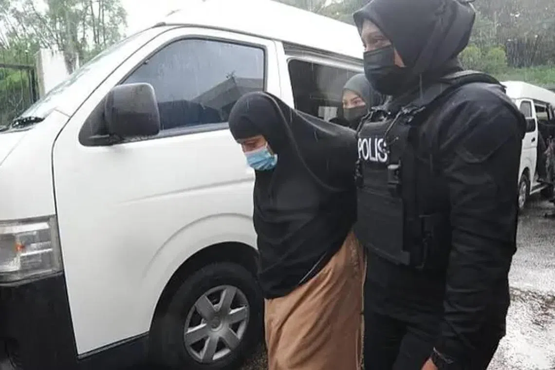 Rosna Jantan being led into Johor Bahru Court Complex to face charges under terrorism activities on June 19, 2024.