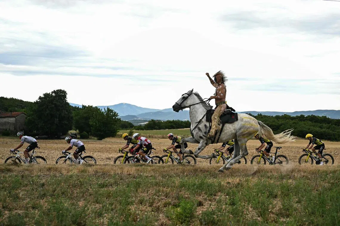 A man on horseback riding alongside the pack of riders during the 17th stage of the 112th edition of the Tour de France cycling race, 160.4 km between Bollene and Valence, southern France, on July 23, 2025. 