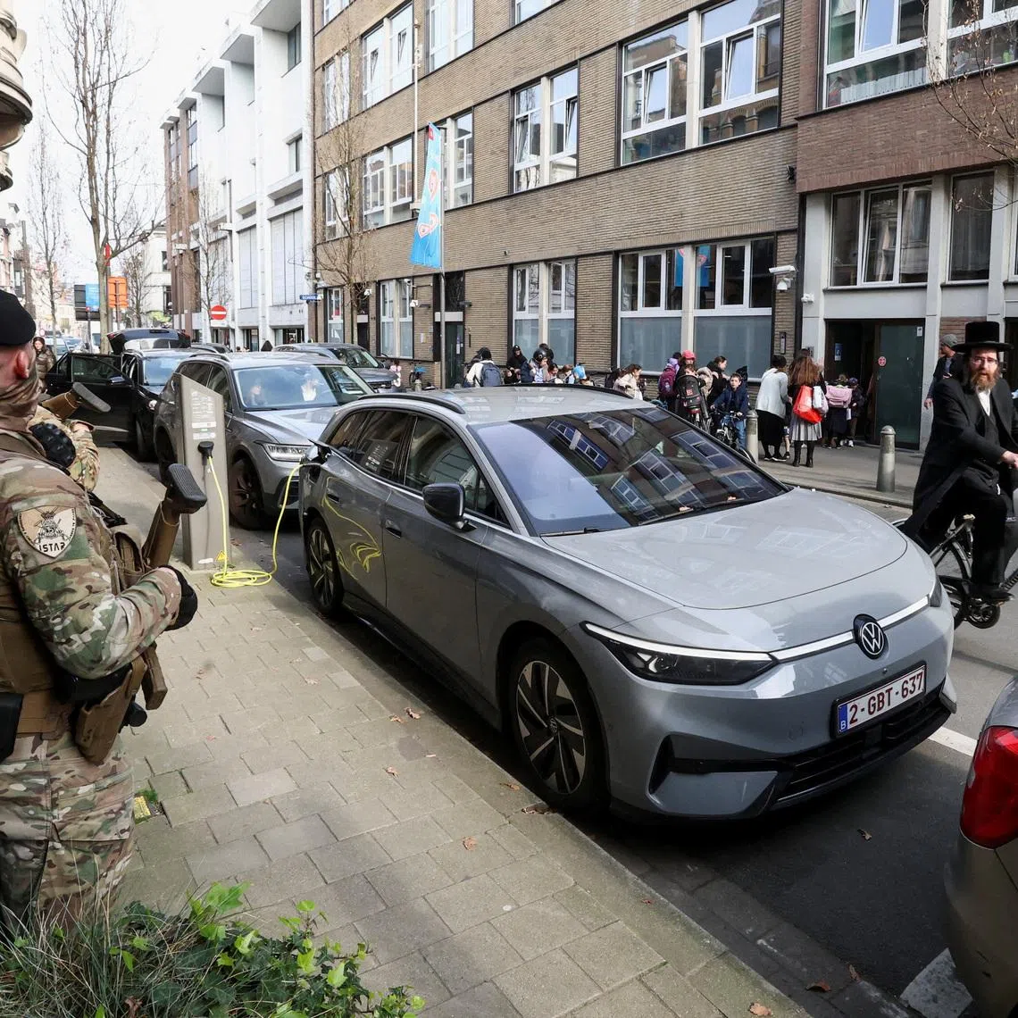A Jewish man rides past Belgian army personnel patrolling a street as part of a deployment of soldiers outside Jewish institutions in Antwerp and Brussels following attacks at Jewish sites in Belgium and other European countries, in Antwerp, Belgium, March 23, 2026. REUTERS/Yves Herman