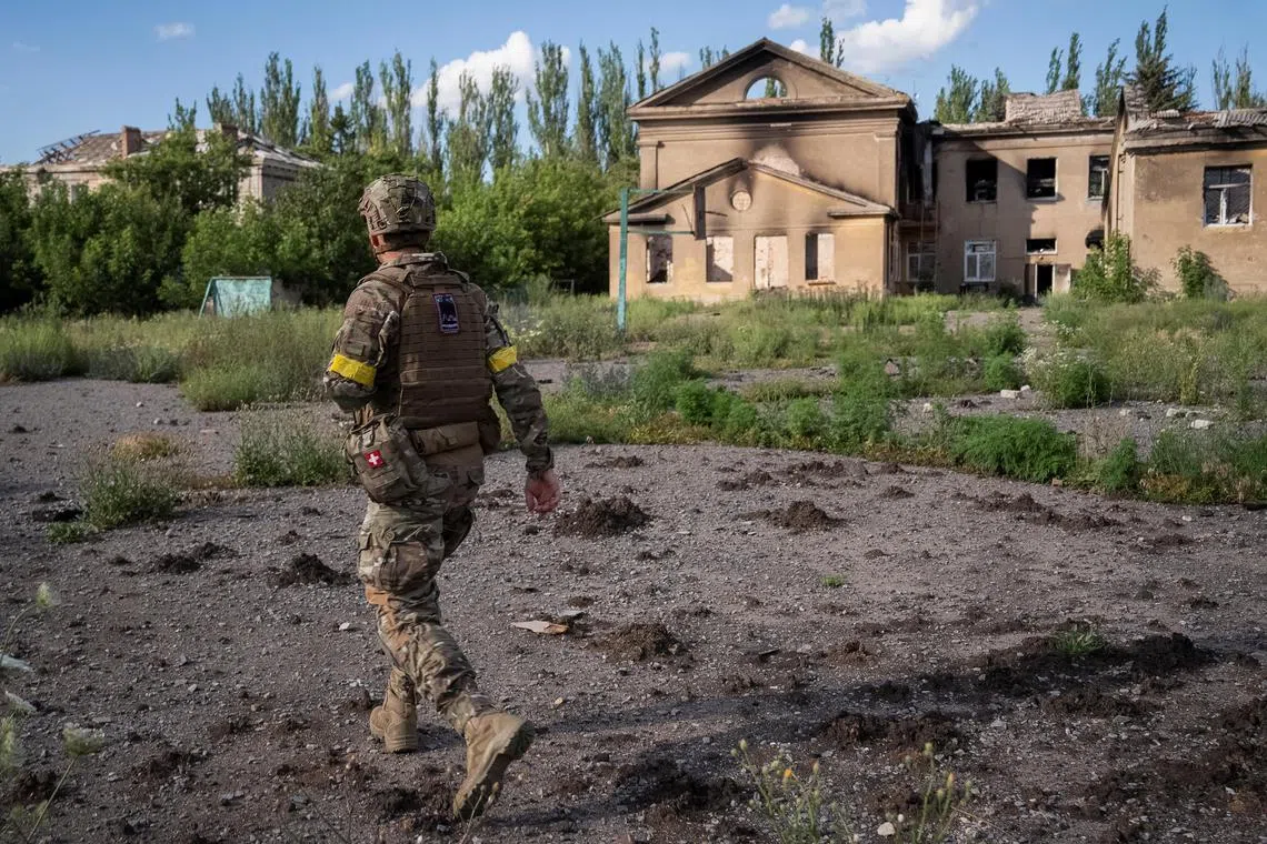 A Ukrainian serviceman walking down a street near the front-line town of Chasiv Yar, in Ukraine's Donetsk region.