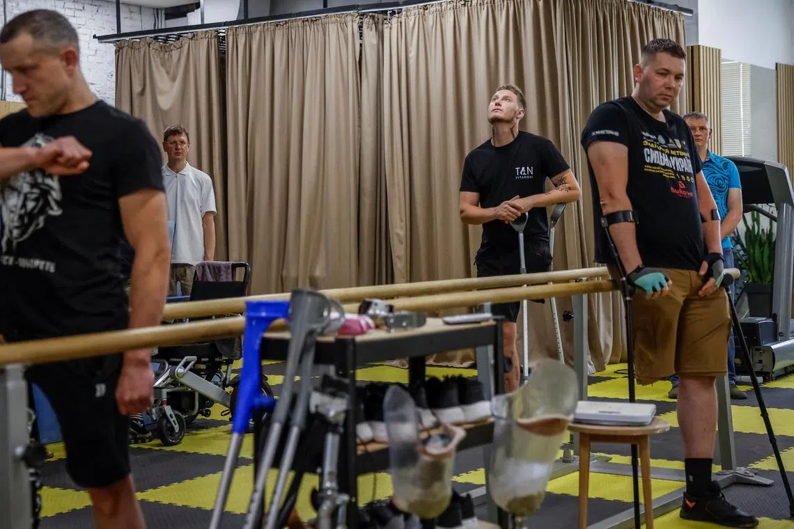 Ukrainian serviceman Oleksiy, 26, who lost most of his left leg after being wounded by an anti-personnel mine, stands with other patients of a rehabilitation centre during a minute of silence, amid Russia's attack on Ukraine, in Kyiv, Ukraine July 3, 2025. REUTERS/Alina Smutko