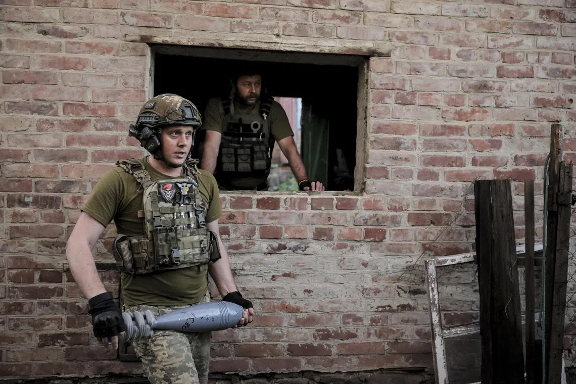 Ukrainian servicemen preparing to fire a mortar towards Russian positions, at an undisclosed location in Ukraine's Donetsk region, on June 4.
