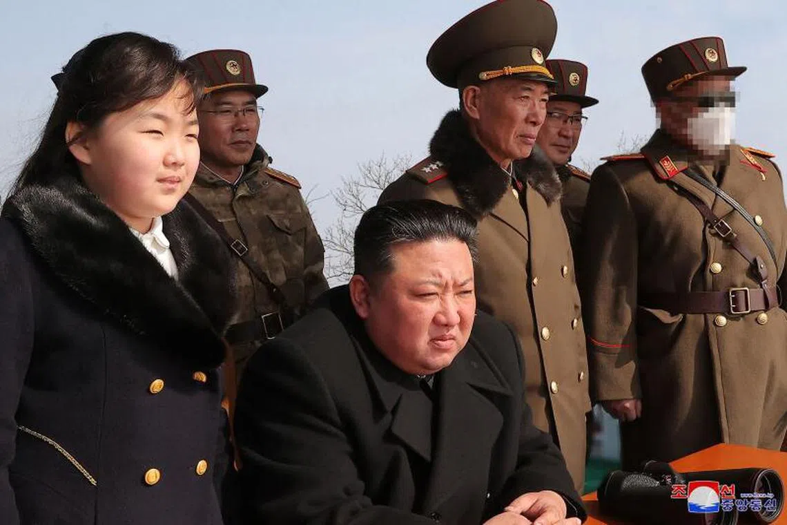 North Korea's leader Kim Jong Un (centre) and his daughter (left) observing a warhead missile launch exercise on March 20, 2023.