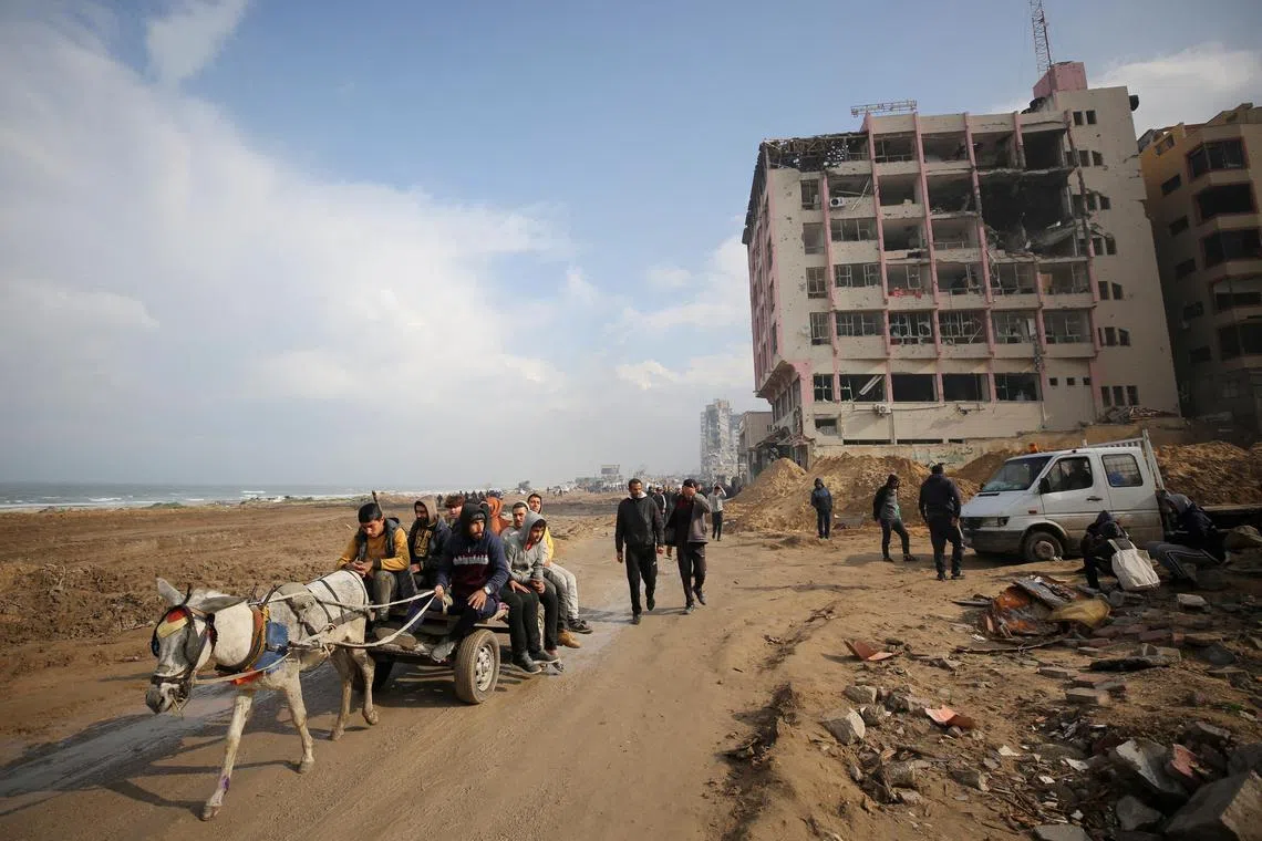Palestinians ride a donkey cart through a destroyed beach road, amid the ongoing conflict between Israel and Hamas, in Gaza City, February 19, 2024. REUTERS/Kosay Al Nemer/File Photo