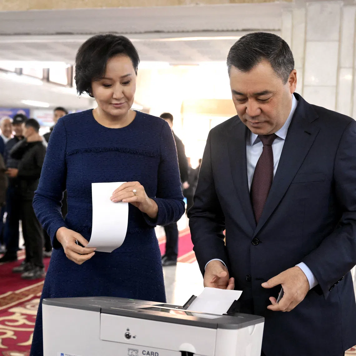 Kyrgyz President Sadyr Japarov casts his ballot as his wife Aigul Japarova stands nearby at a polling station during the snap parliamentary election in Bishkek, Kyrgyzstan November 30, 2025. Kyrgyz Presidential Press Service/Handout via REUTERS