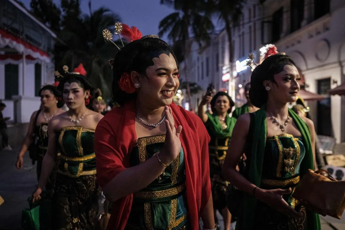 This photo taken on August 19, 2023 shows Ayi Nur Ringgo (C), a dancer of Lengger Lanang, the Indonesian cross-dressing folk art, waving to onlookers before a performance in Jakarta's old downtown area of Kota Tua. The Lengger Lanang dance tradition, rooted in 16th-century fertility and harvest rituals from Central Java province, was once a highly revered folk art where performers were idolised and respected as performers able to embody both genders. But it is being challenged as prejudice grows against anything perceived as queer-related. (Photo by Yasuyoshi CHIBA / AFP) / To Go with AFP story Indonesia-culture-dance-gender, FOCUS by Dessy Sagita and Arbi Anugrah