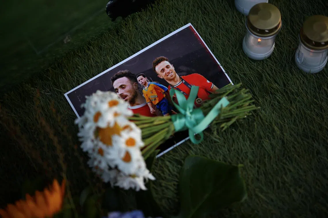Flowers lie on photographs of Liverpool's Portuguese soccer player Diogo Jota, who died in a car crash near Zamora, Spain, outside Gondomar stadium in Gondomar, Portugal, July 3, 2025. REUTERS/Pedro Nunes