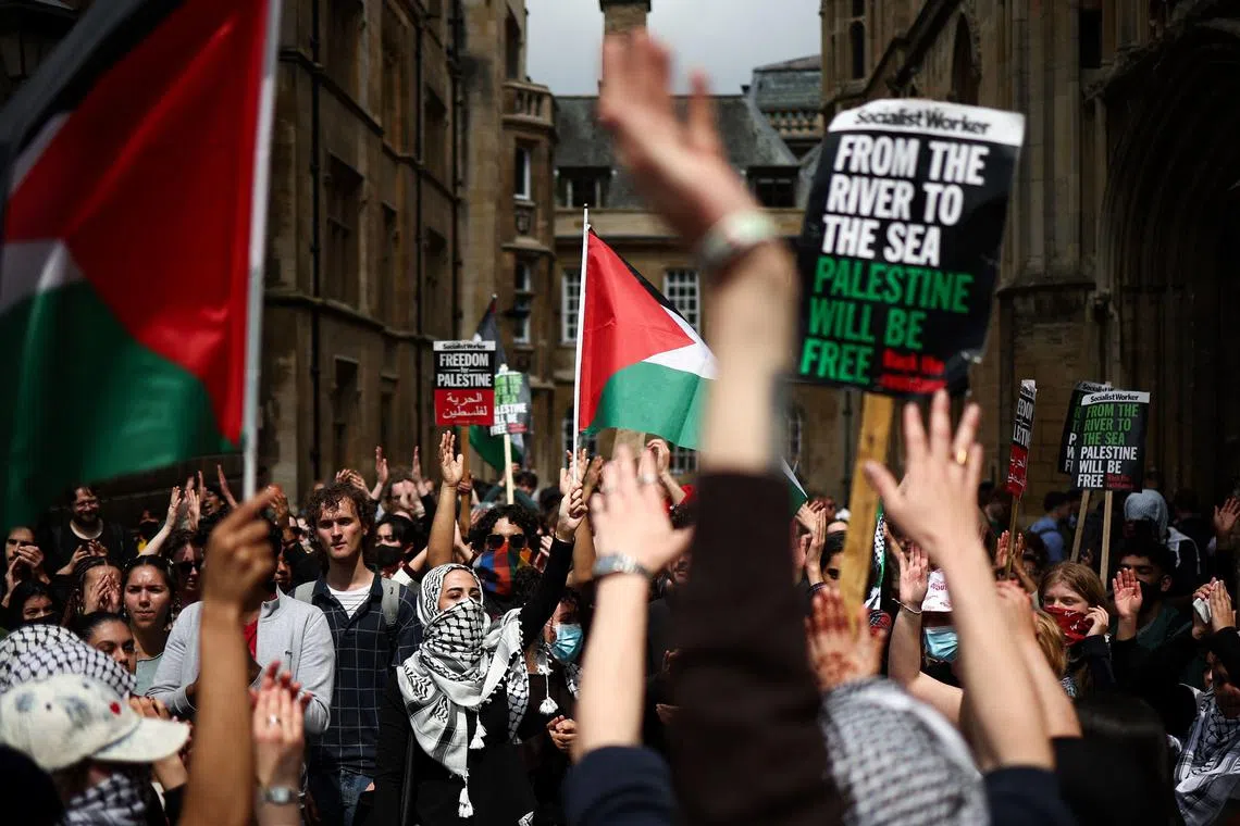 Students wave Palestinian flags and placards at Cambridge University, eastern England on May 7, 2024. 