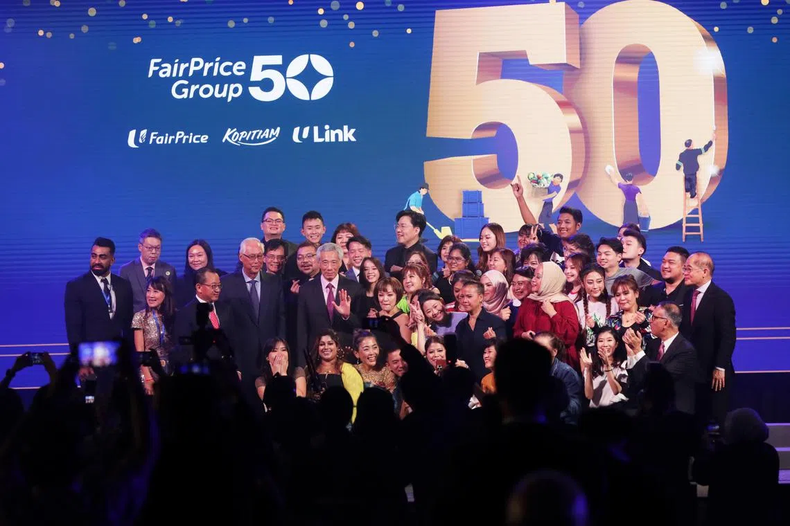 Prime Minister Lee Hsien Loong, accompanied by Emeritus Senior Minister Goh Chok Tong and FairPrice Group deputy chairman Seah Kian Peng, posing with the performers and FairPrice Group leaders at the group’s 50th anniversary celebrations at Marina Bay Sands Convention Centre on Saturday.
