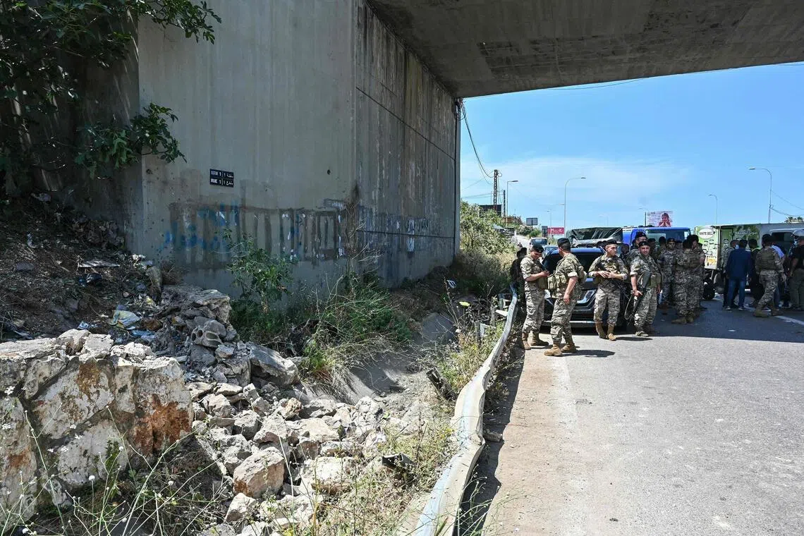 Lebanese soldiers secure the site of an Israeli drone strike that killed the passengers of a vehicle on the Khaldeh highway at the southern entrance to Beirut on June 3.