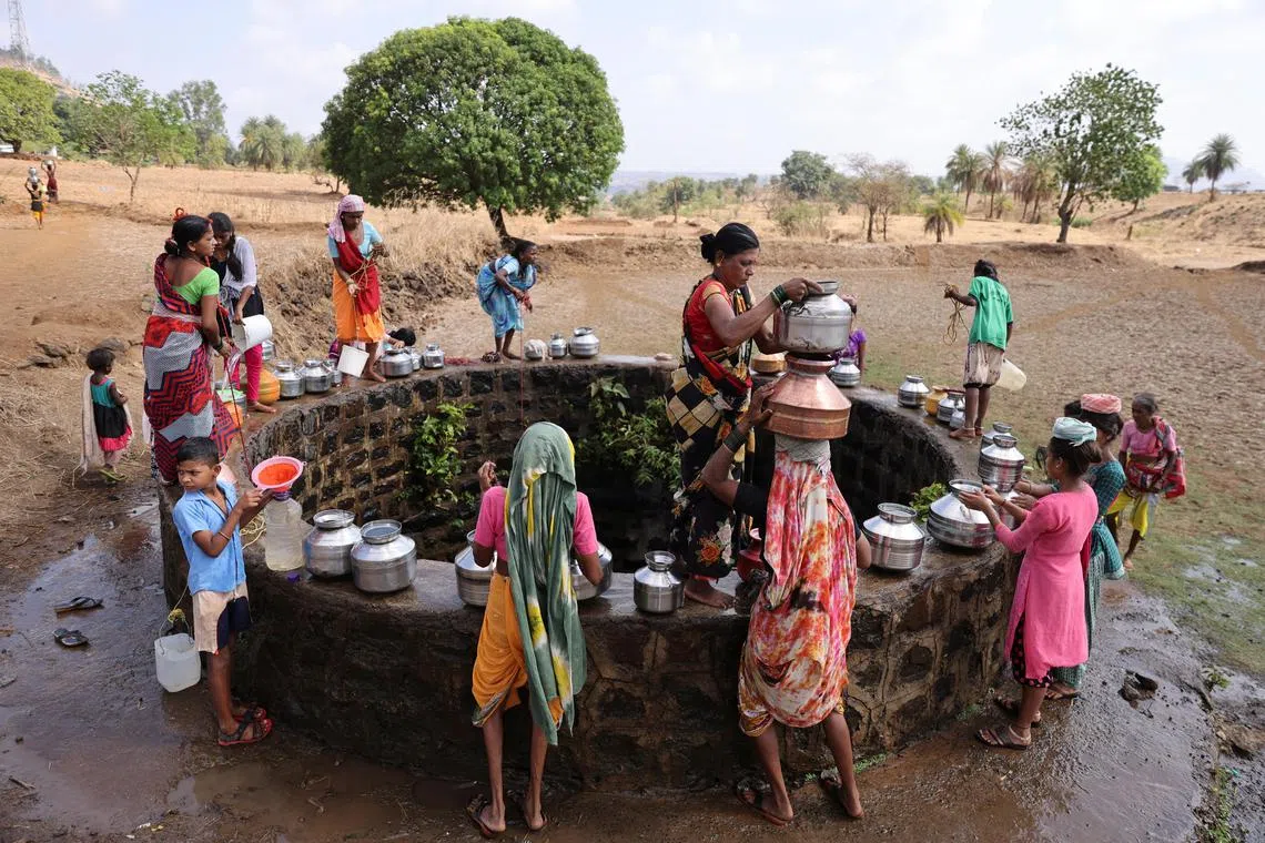 Women gather around a well to draw water from it in Telamwadi, near Mumbai, India.