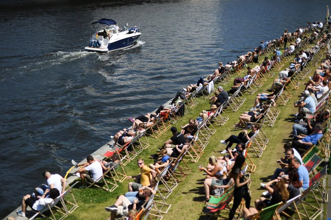 FILE PHOTO: People enjoy the sunny weather on bank of Spree river during the Catholic feast days of Pentecost, in Berlin, Germany June 5, 2022. REUTERS/Annegret Hilse