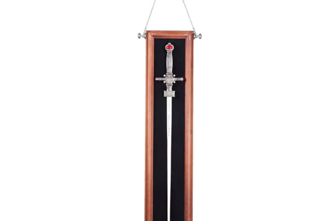 The pointed, silver sword is 85cm long and comes affixed to a wood display plaque.