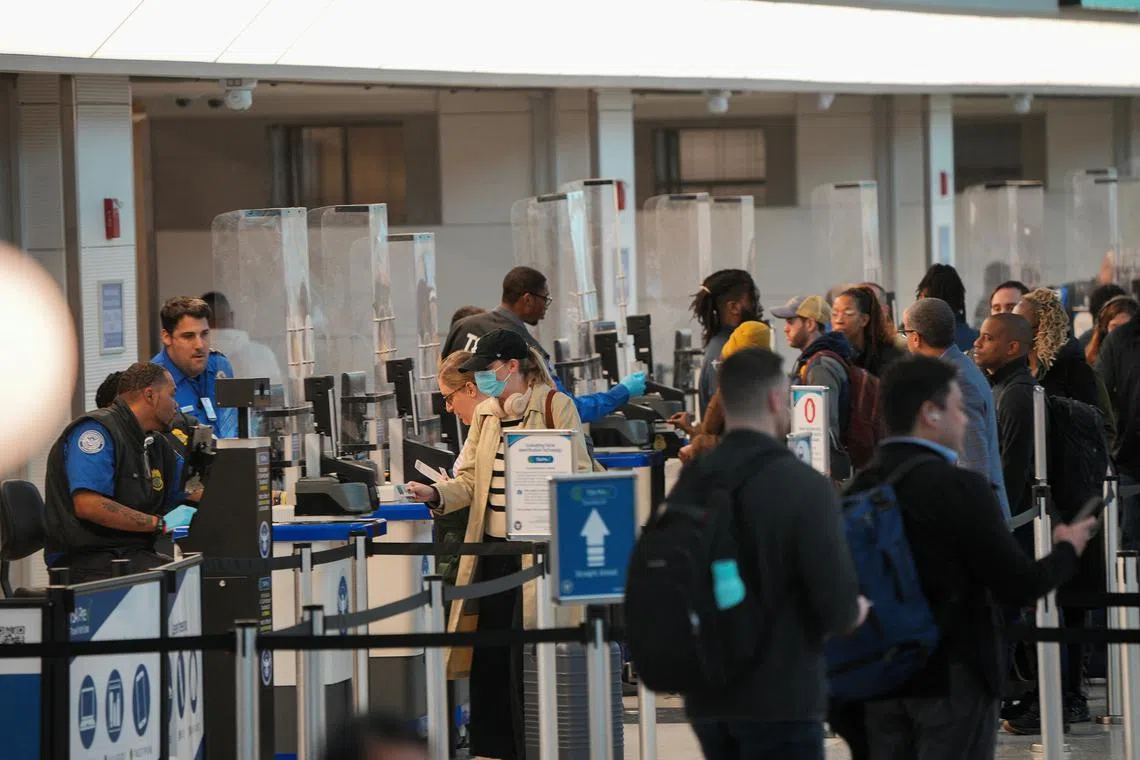 FILE PHOTO: Passengers stand in line at Ronald Reagan Washington National Airport in Arlington, Virginia, U.S., January 31, 2025. REUTERS/Jeenah Moon/File Photo