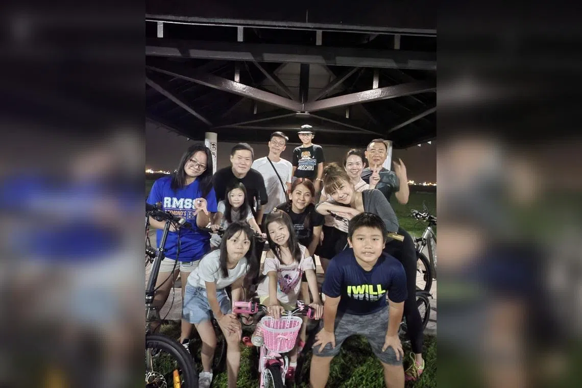 Singaporean actor Mark Lee (background, in white) with his family members and two other families at East Coast Park during one of their weekend night cycling sessions.
