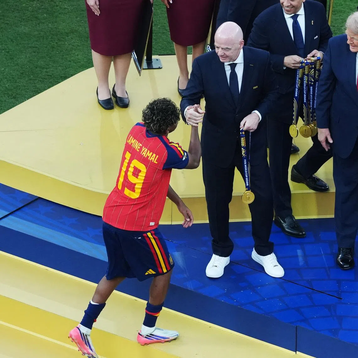 Soccer Football - FIFA World Cup 2026 - Final - Spain v Argentina - New York/New Jersey Stadium, East Rutherford, New Jersey, U.S. - July 19, 2026 Spain's Lamine Yamal receives the winner's medal from FIFA President Gianni Infantino and U.S. President Donald Trump during the trophy presentation IMAGN IMAGES via Reuters/James Lang