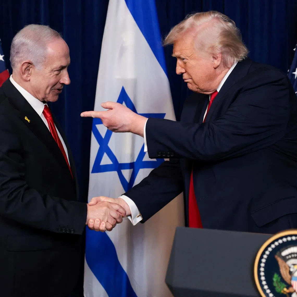 U.S. President Donald Trump points his finger towards Israeli Prime Minister Benjamin Netanyahu as they shake hands during a press conference after meeting at Trump’s Mar-a-Lago club in Palm Beach, Florida, U.S., December 29, 2025. REUTERS/Jonathan Ernst