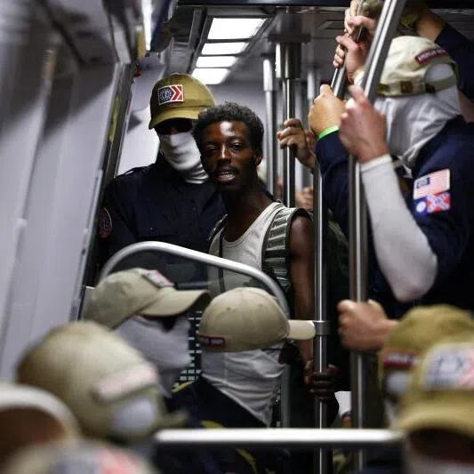 A passenger looks on as members of the white supremacist group Patriot Front travel on the Washington Metro during Fourth of July celebrations.