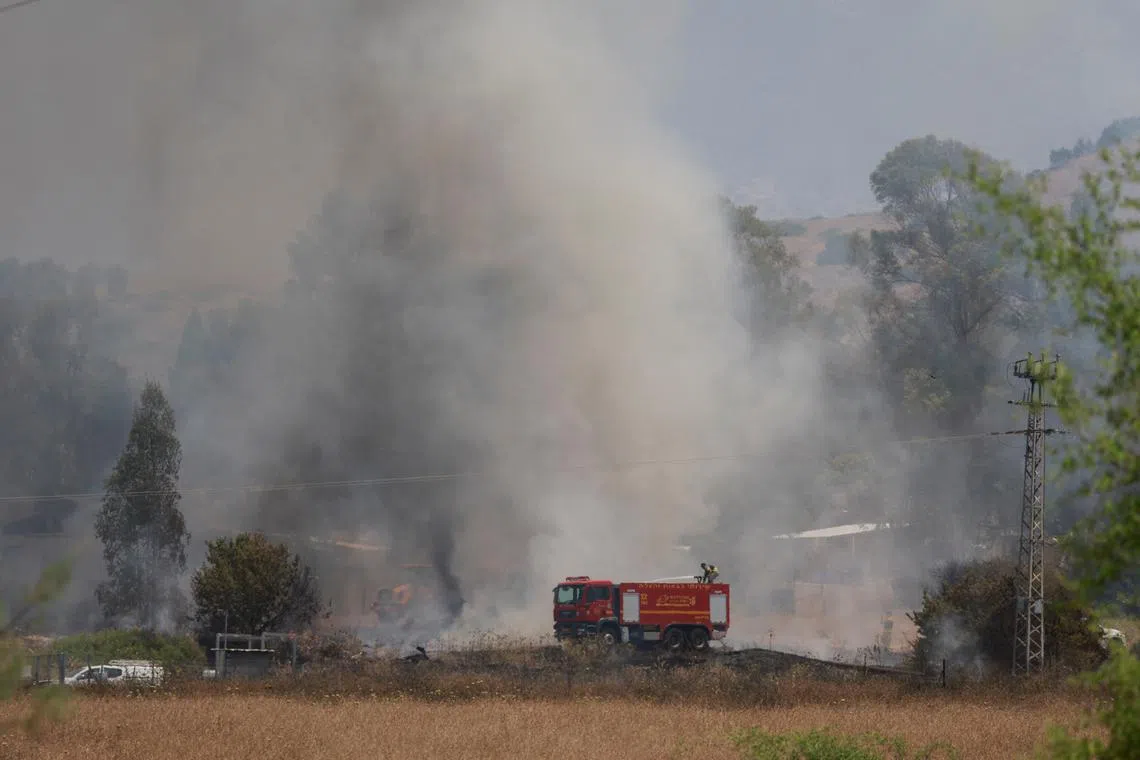 Firefighters respond to a fire near a rocket attack from Lebanon, amid ongoing cross-border hostilities between Hezbollah and Israeli forces, near Kiryat Shmona, northern Israel, June 14, 2024. REUTERS/Ammar Awad