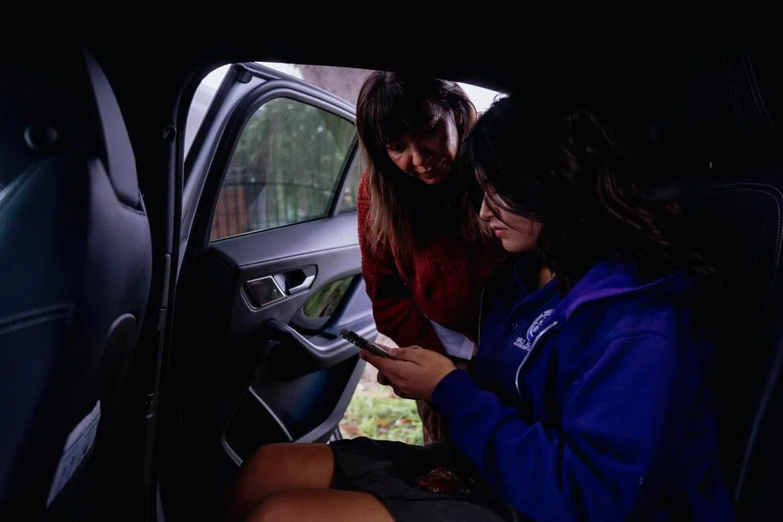 Ms Veronica Rivera helps her 13-year-old daughter, Alexis Munoz, settle into a robotaxi in Los Angeles on Dec 16, 2025. For most parents that turn to Waymo, the absence of a driver is its shining feature.