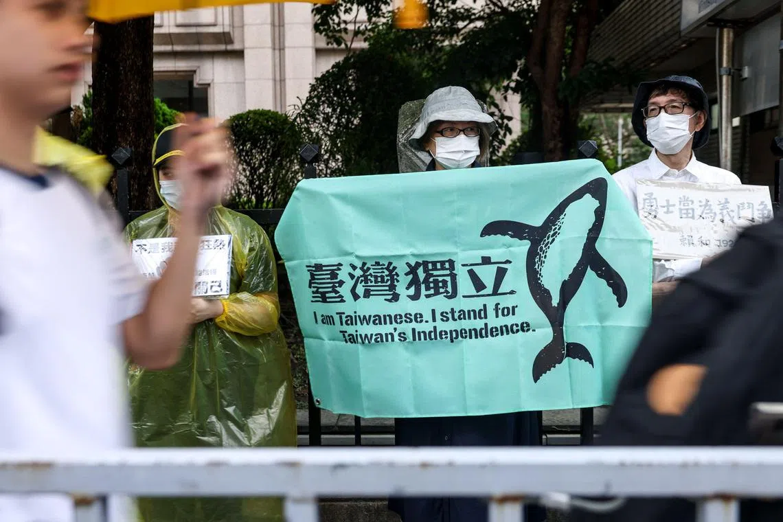 A supporter of the ruling Democratic Progressive Party (DPP) holds a sign to support Taiwan’s independence during the vote for the Parliament reform bill in Taipei on May 28, 2024. (Photo by I-Hwa CHENG / AFP)