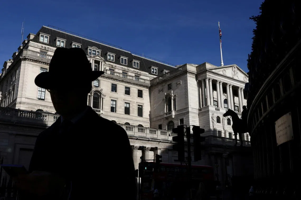 FILE PHOTO: A person walks past the Bank of England in London, Britain, October 22, 2021. REUTERS/Tom Nicholson/File Photo