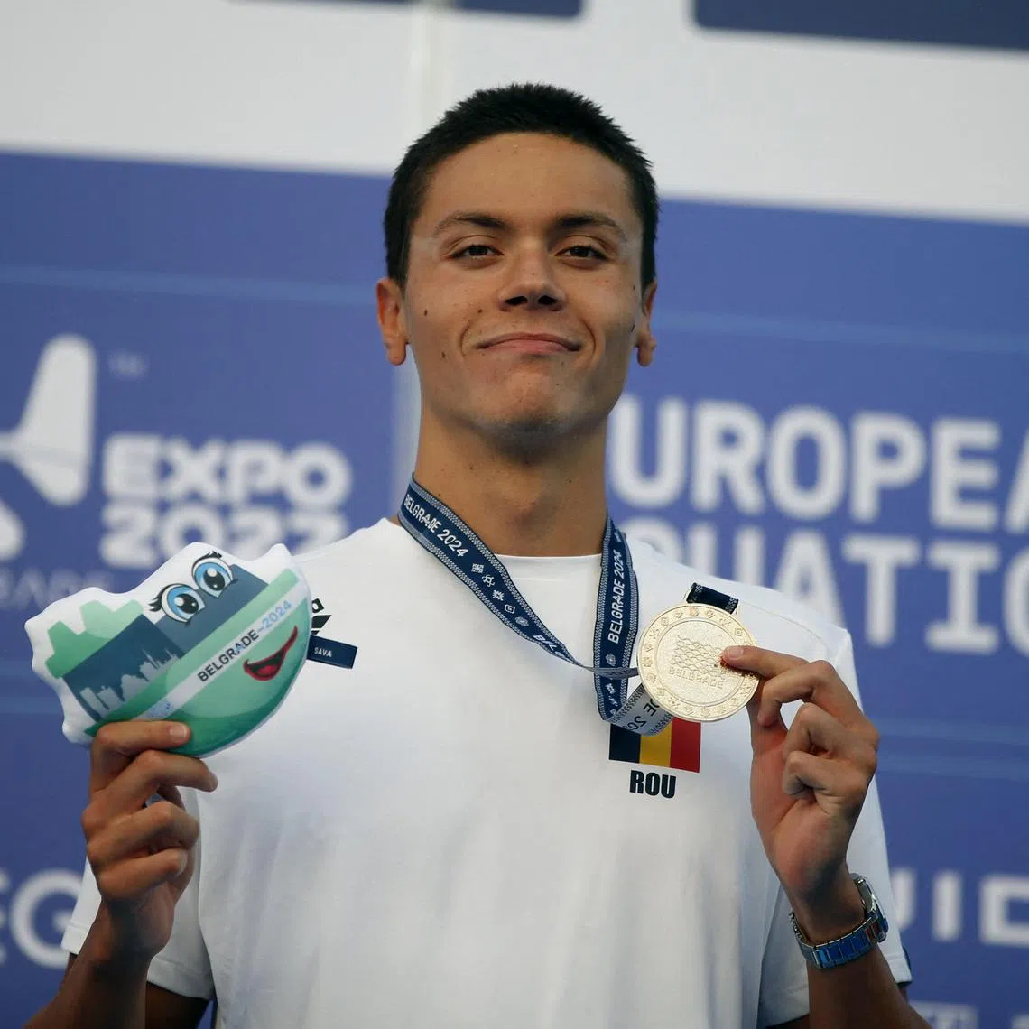 Romania's David Popovici celebrates on the podium after winning the 100m free at the European Championships.