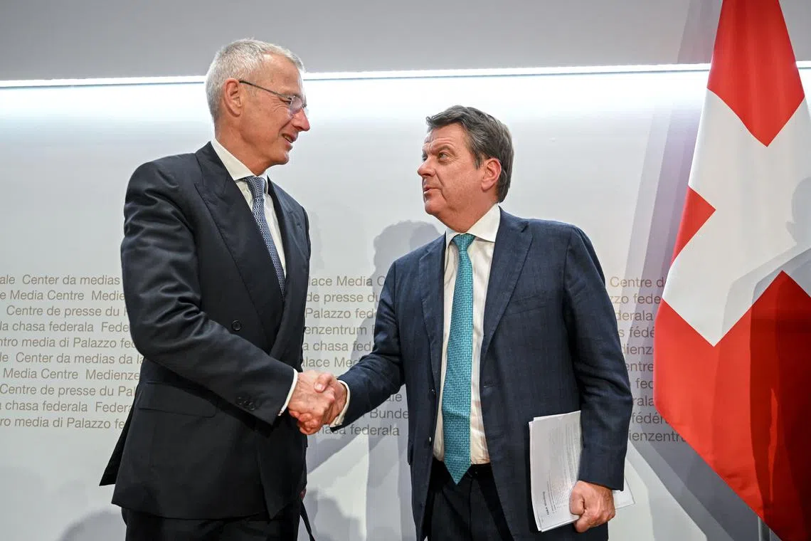 UBS Chairman Colm Kelleher (right) shakes hands to Credit Suisse chairman Axel Lehmann after a press conference on March 19, 2023.