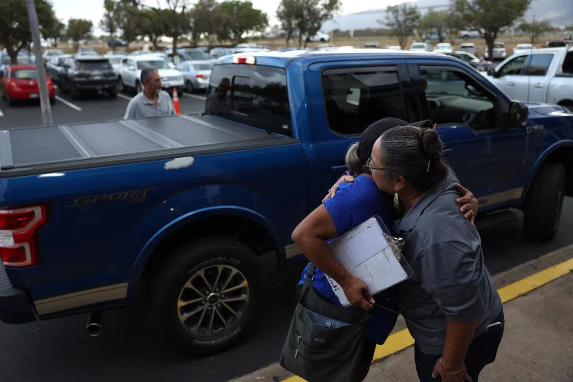 Volunteers with King's Cathedral Maui embracing while taking donations for wildfire victims in Kahului, Hawaii, on Aug 10, 2023. 