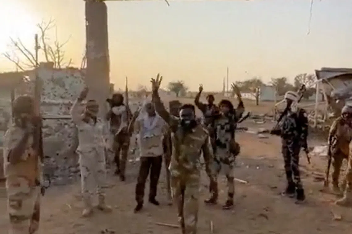 Members of Sudan's paramilitary Rapid Support Forces (RSF) stand in front of the main gate of the 22nd SAF Infantry Division, in Babanusa, Sudan, in this screengrab obtained from a social media video released December 1, 2025. Social Media/via REUTERS