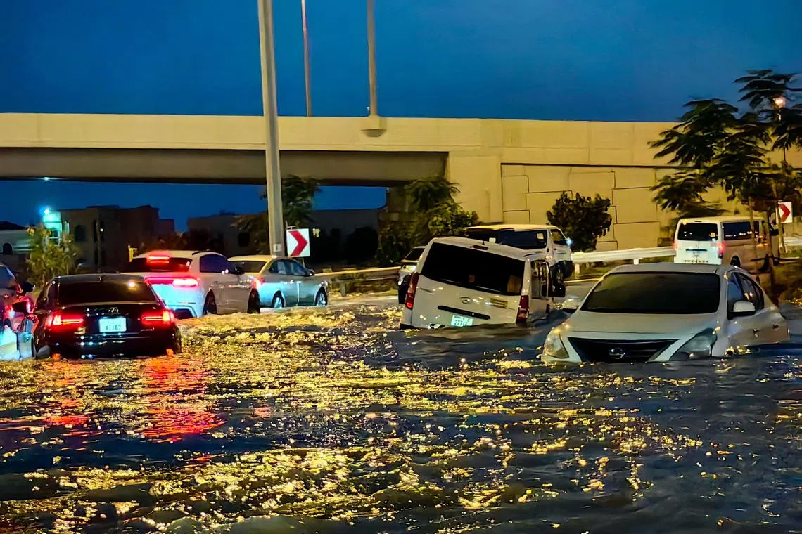 Cars drive in a flooded street following heavy rains in Dubai on April 17.