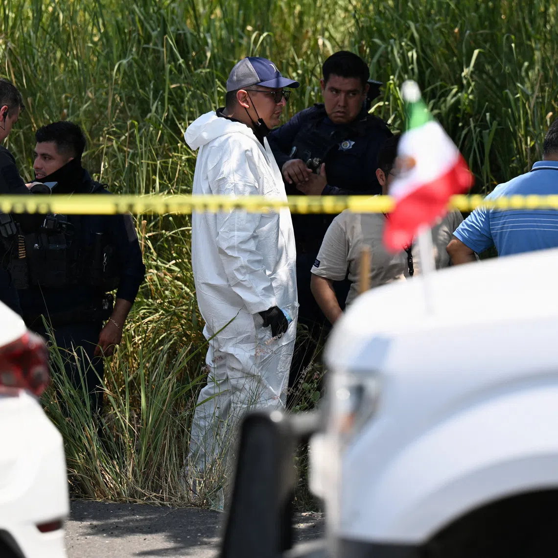 A forensic technician and police officers stand at the scene where Zenyazen Escobar, a federal legislator from Veracruz, home to some of Mexico's major oil complexes, was found dead with at least one gunshot wound on a highway linking the municipality of Puente Nacional with the state capital, Xalapa, Mexico, September 4, 2026. REUTERS/Yahir Ceballos