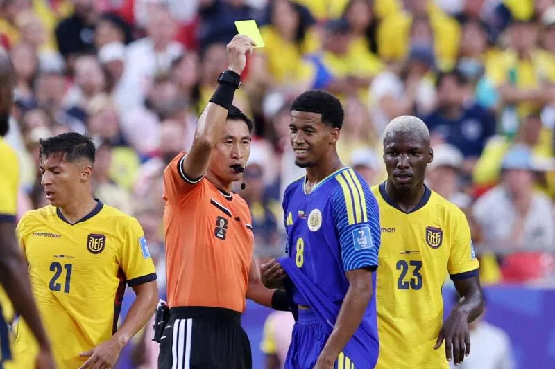 Curacao’s Livano Comenencia is shown a yellow card by referee Ma Ning in their World Cup Group E match against Ecuador on June 20.