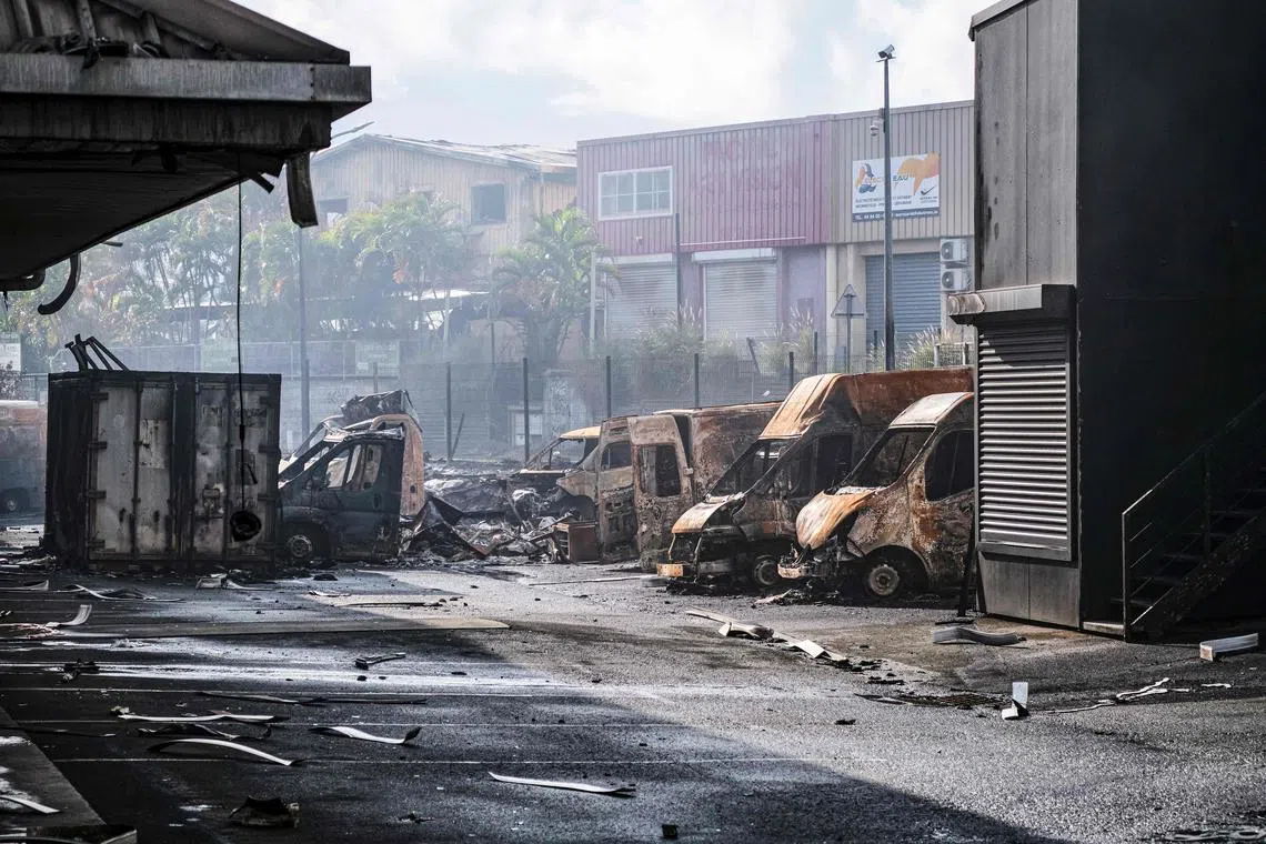A burnt vehicle is seen in the Normandy industrial zone in Noumea, New Caledonia, on May 20.