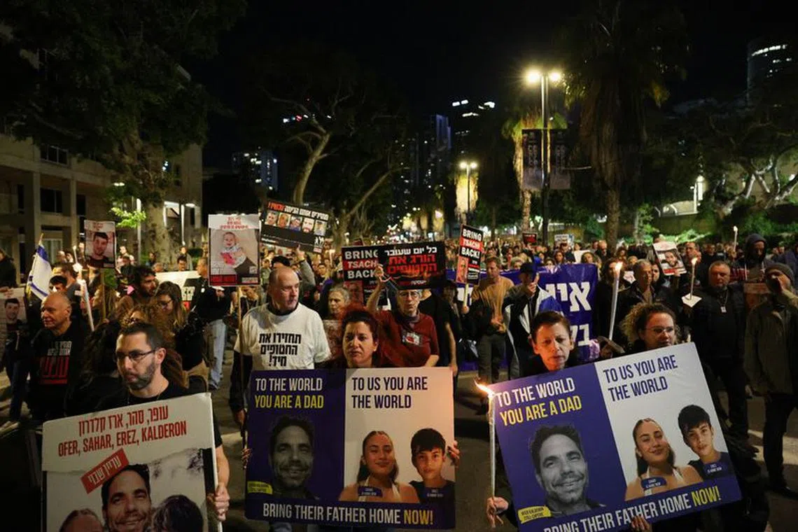 People hold signs as they protest following an announcement by Israel's military that they had mistakenly killed three Israeli hostages being held in Gaza by Palestinian Islamist group Hamas, at a demonstration in Tel Aviv, Israel, December 15, 2023. REUTERS/Violeta Santos Moura