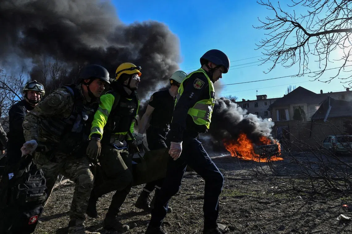 Emergency workers carry an injured woman at a site of a Russian missile strike, amid Russia's attack on Ukraine, in Zaporizhzhia, Ukraine April 5, 2024. REUTERS/Stringer