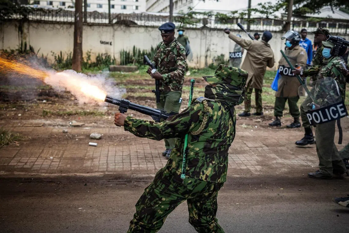 A Kenya police officer firing tear gas during a demonstration against tax hikes in downtown Nairoibi, on June 20, 2024. 