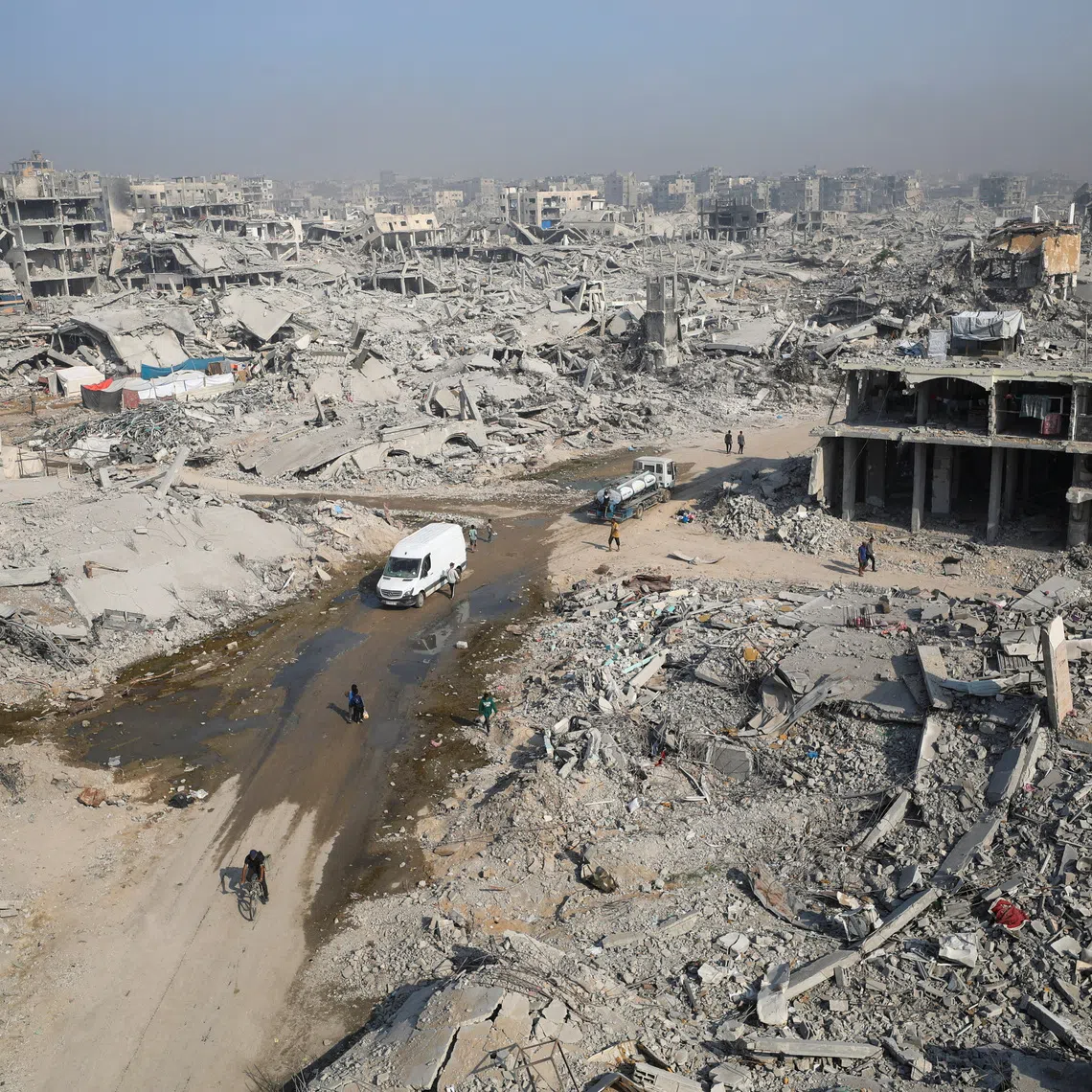 Palestinians walk past the rubble of destroyed buildings, amid a ceasefire between Israel and Hamas, in Gaza City, November 5, 2025. REUTERS/Dawoud Abu Alkas
