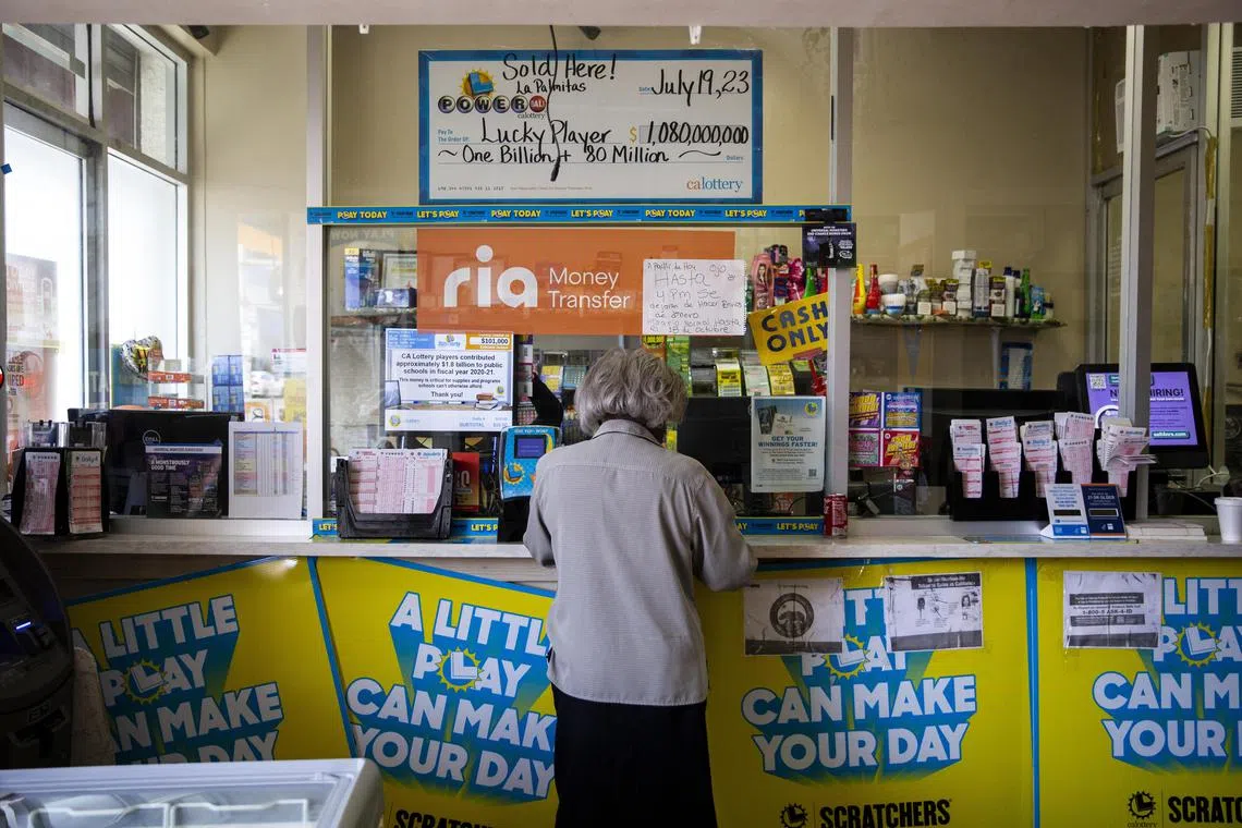 A woman buys lottery tickets at Las Palmitas Mini Market, where a winning Powerball lottery ticket was sold in July.